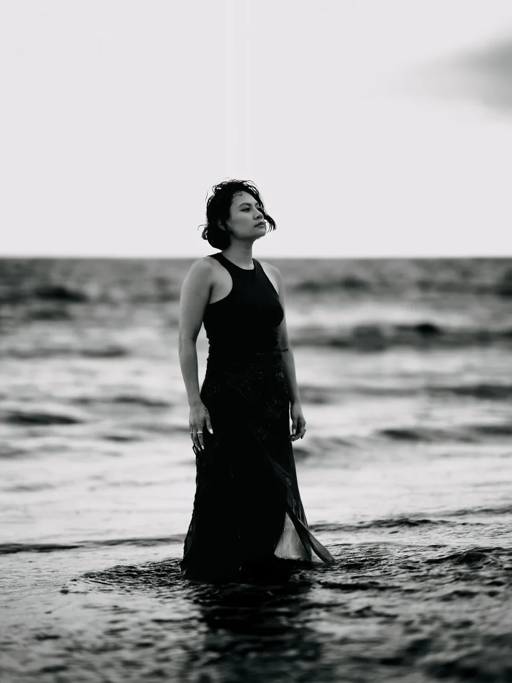 Black-and-white portrait of Shaina Rae standing in the sea