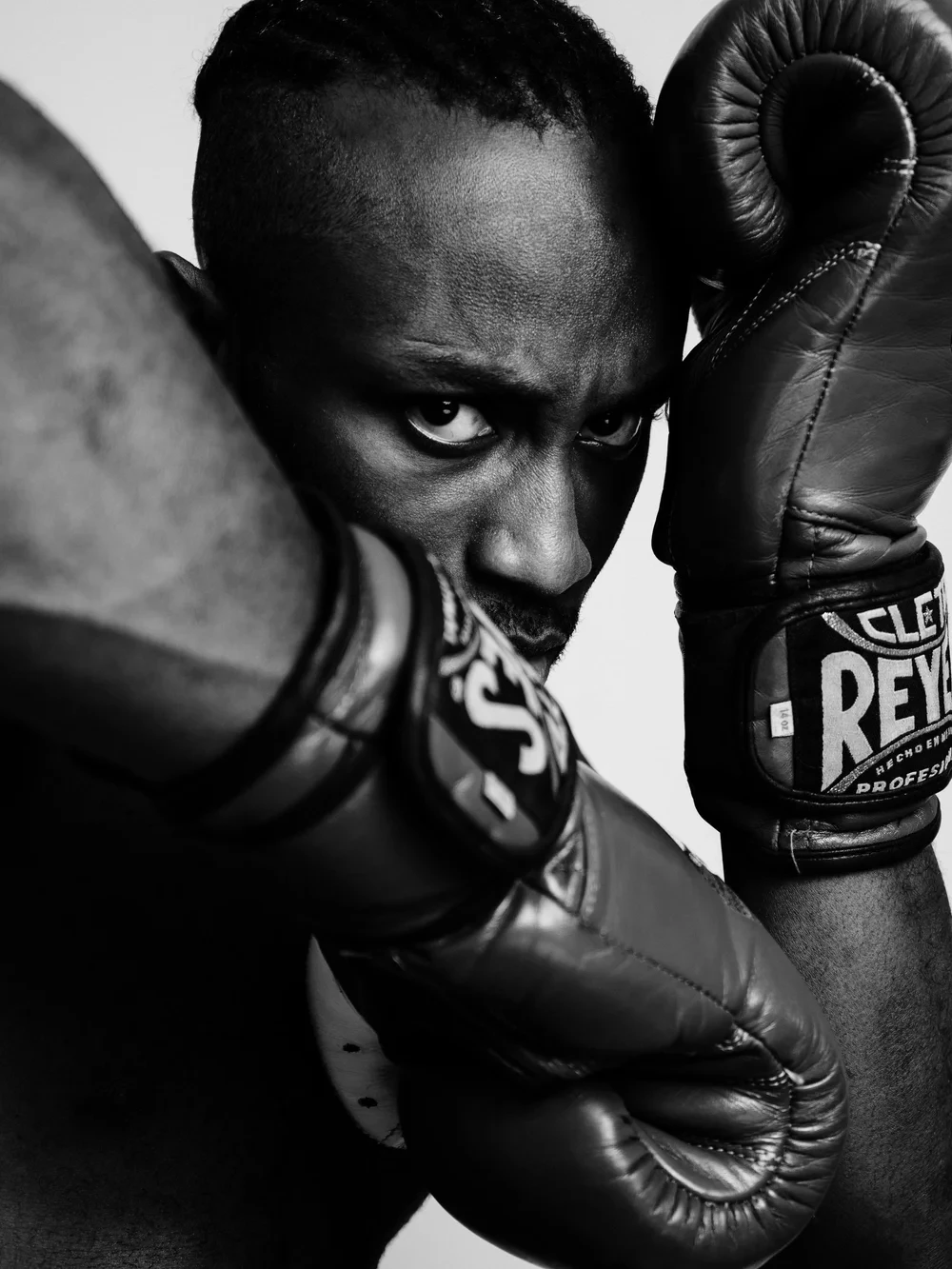 Close black-and-white portrait of Paul Bossman with boxing gloves raised